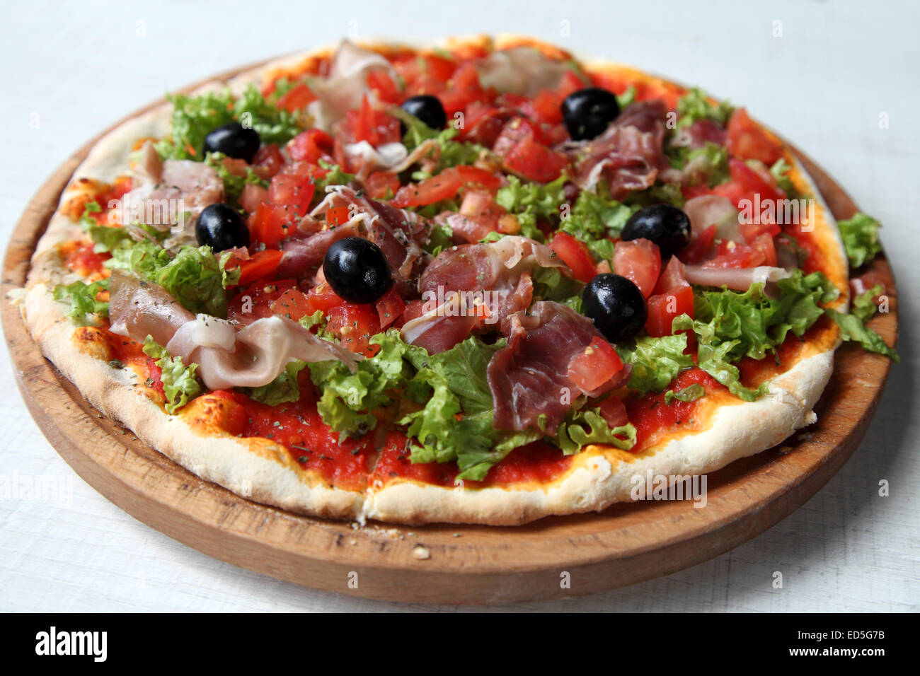 Thin crust pizza, made with Serbian ham, served at the Kasina bar in Belgrade, Serbia. Olives top the pizza. Stock Photo