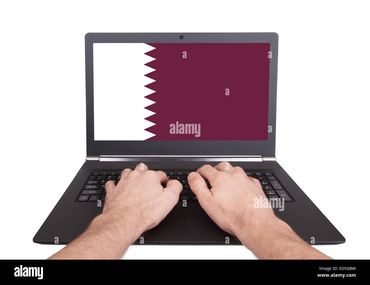 Hands working on laptop showing on the screen the flag of Qatar Stock