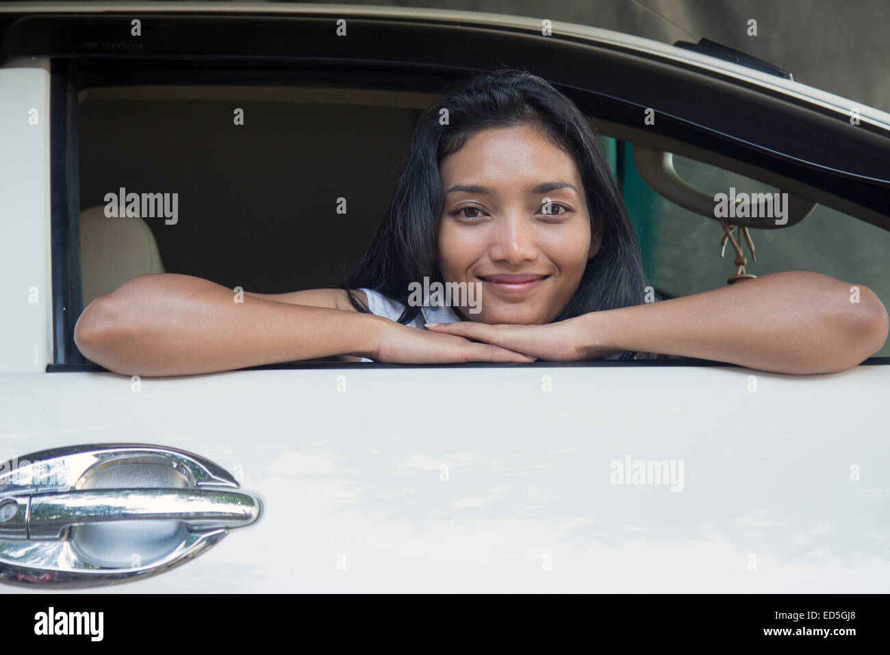 Young woman sitting in a car and looking out the window Stock Photo