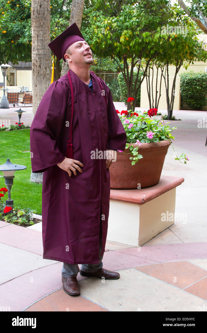 Mature college graduate in cap and gown looking up and forward Stock Photo