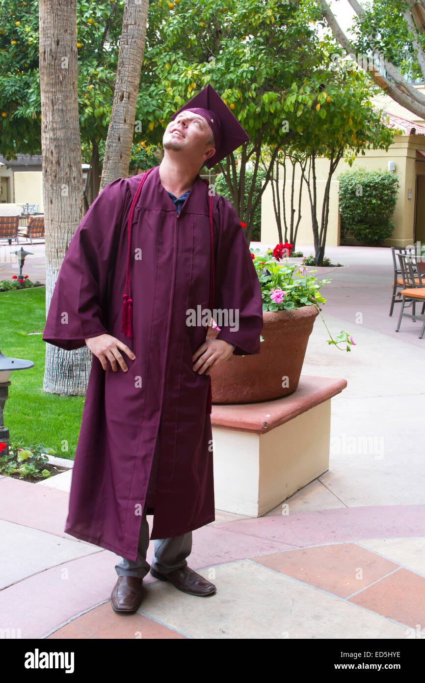 Mature college graduate in cap and gown looking up Stock Photo