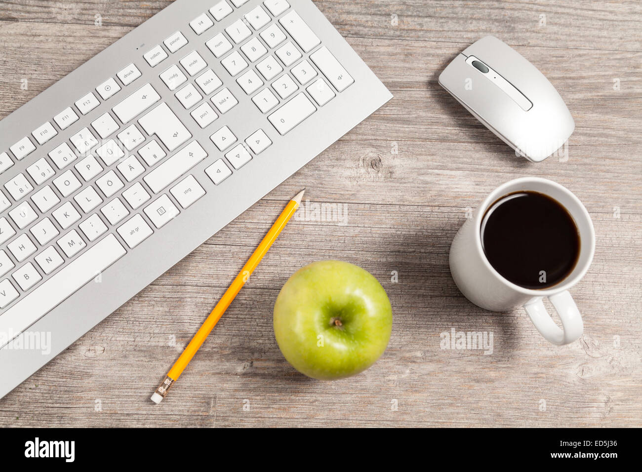 desk with keyboard and mouse and green apple Stock Photo