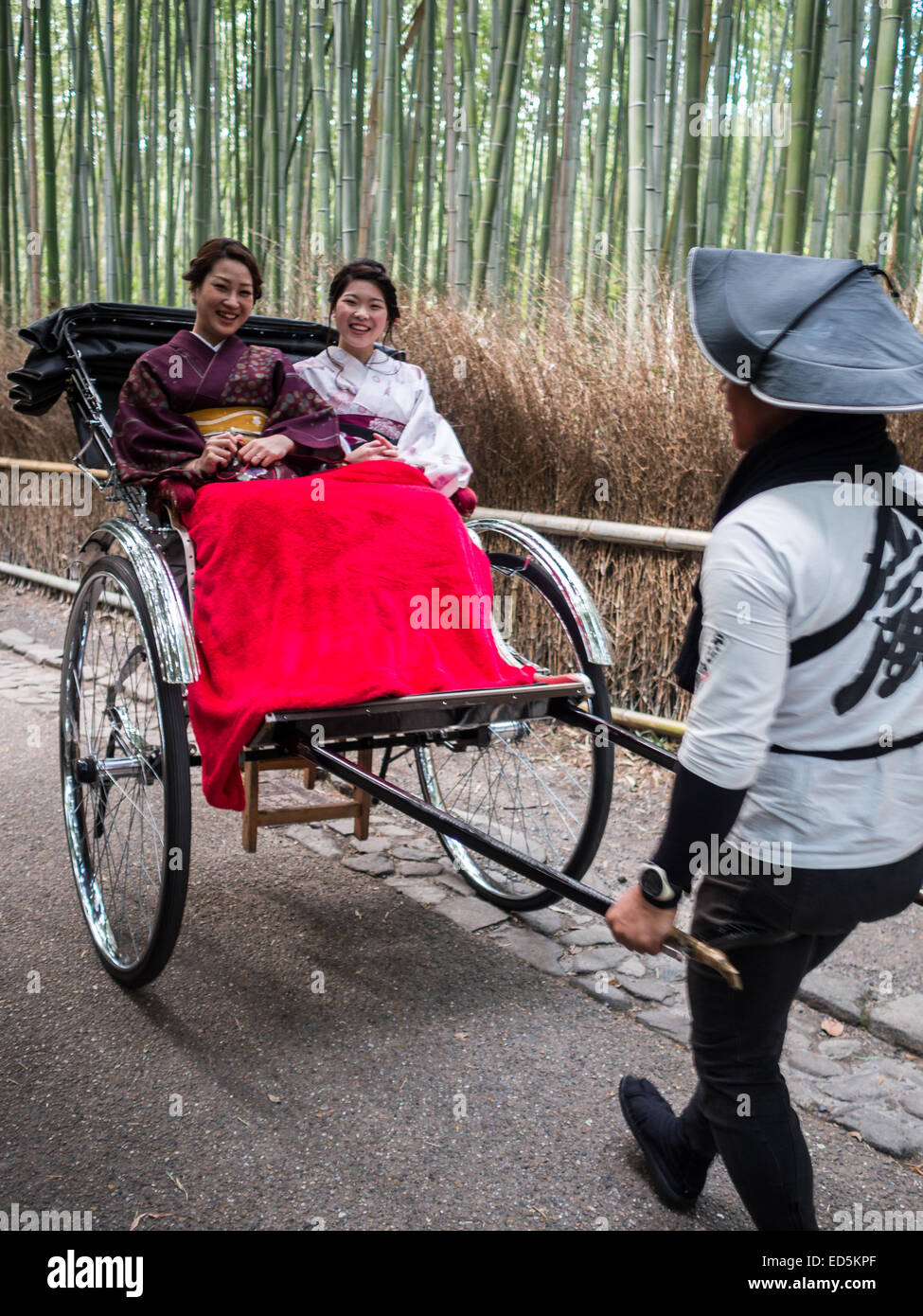 Two women smile while riding in a traditional Japanese rickshaw Stock Photo