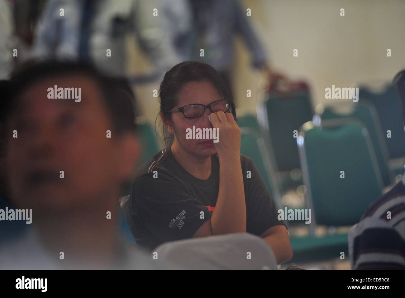 Surabaya, Indonesia. 29th Dec, 2014. A woman wipes tears as family members of passengers on AirAsia Flight QZ8501 gather at Juanda International Airport in Surabaya, Indonesia, Dec. 29, 2014. Air Asia Indonesia has released information about the 162 passengers and crew members on Flight QZ8501, which lost contact with the air traffic control Sunday morning. Credit:  Zulkarnain/Xinhua/Alamy Live News Stock Photo
