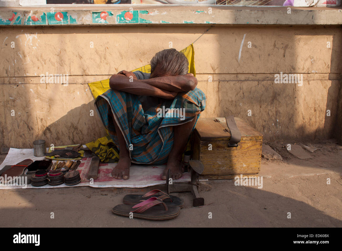 A shoemaker sleeping in his stall on street during a nationwide strike called by the Bangladesh Nationalist Party (BNP)-led alliance in Dhaka. Bangladesh opposition activists clashed with police during a nationwide strike, leaving a woman dead and several injured as tension grew in the politically volatile country ahead of the first anniversary of a controversial election. Stock Photo