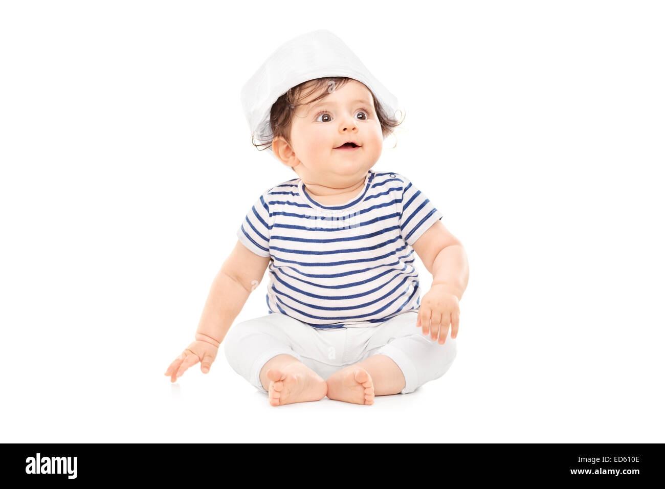 Cute baby girl in sailor outfit sitting on the floor isolated on white background Stock Photo