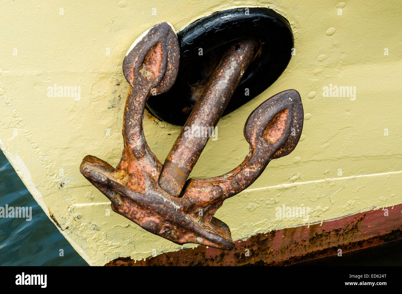 Big, rusty anchor on a light yellow ship in the harbour of Marken Stock ...