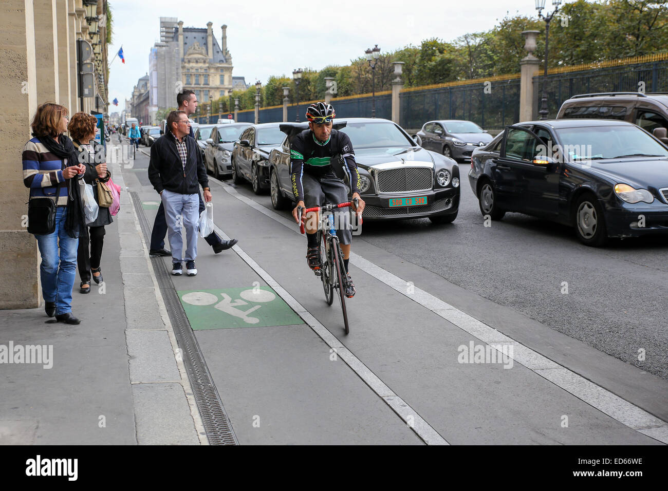 man biking bike lane car traffic Paris Stock Photo