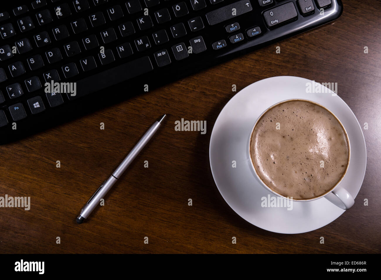 cup coffee, keyboard and pen on desk Stock Photo