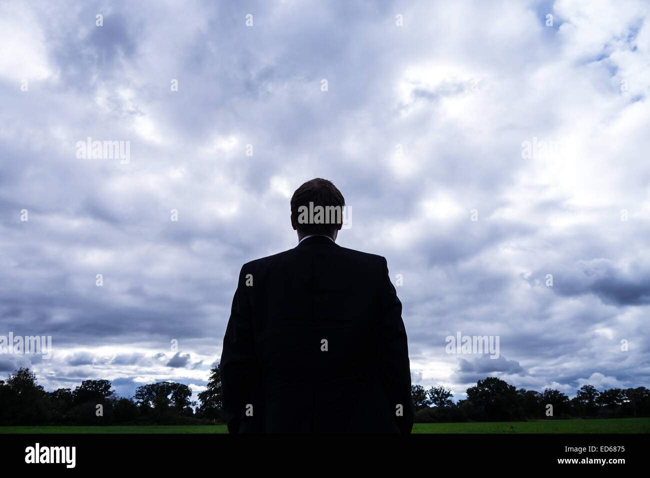 businessman in landscape and stormy clouds Stock Photo