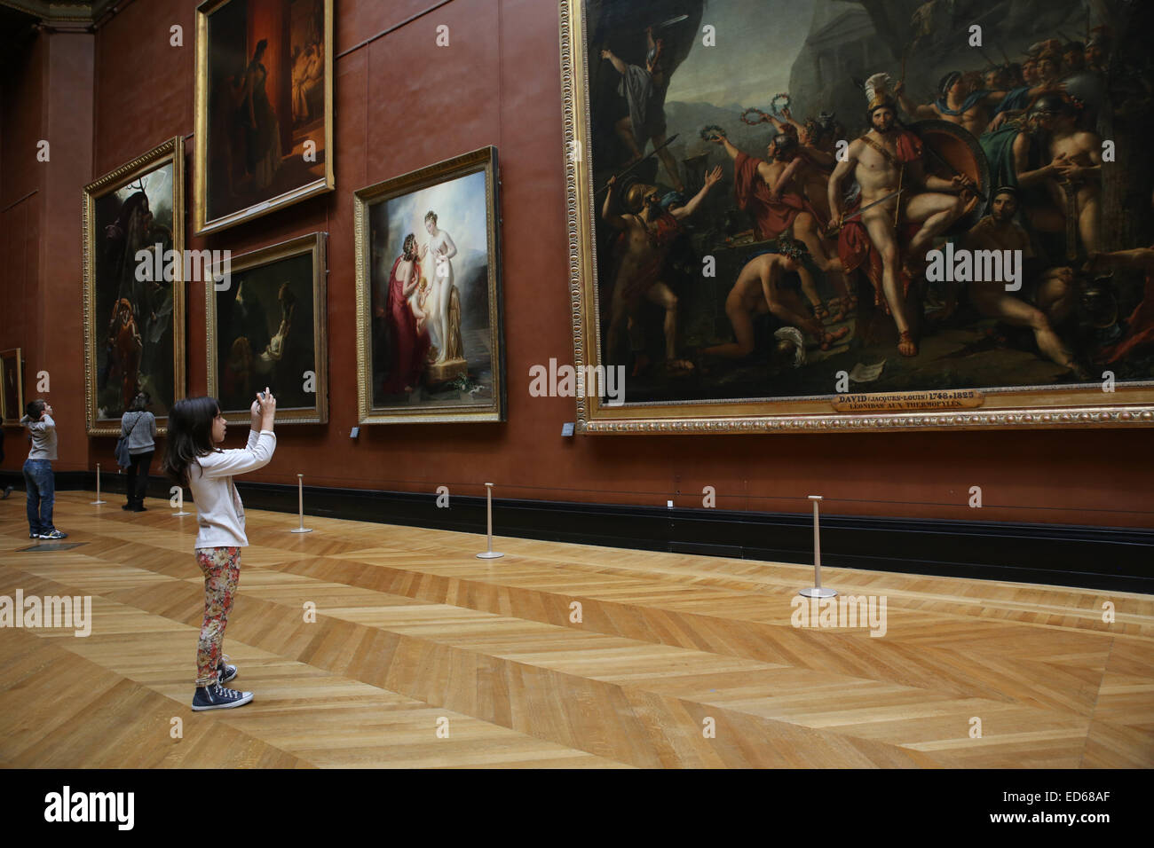 young girl taking photo inside Louvre museum art paintings Stock Photo