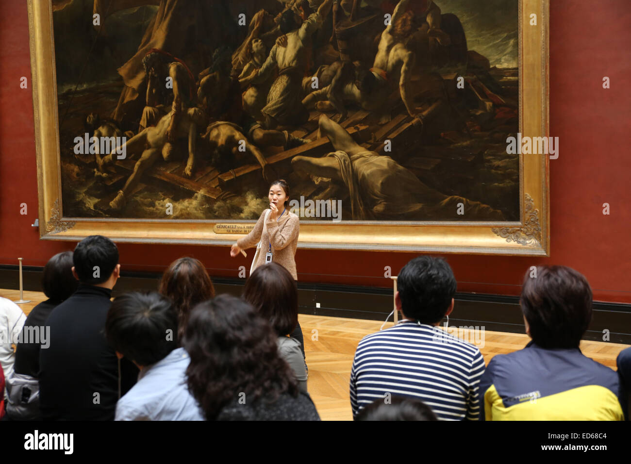 Asian female tour guide present tour group inside Louvre museum Stock Photo