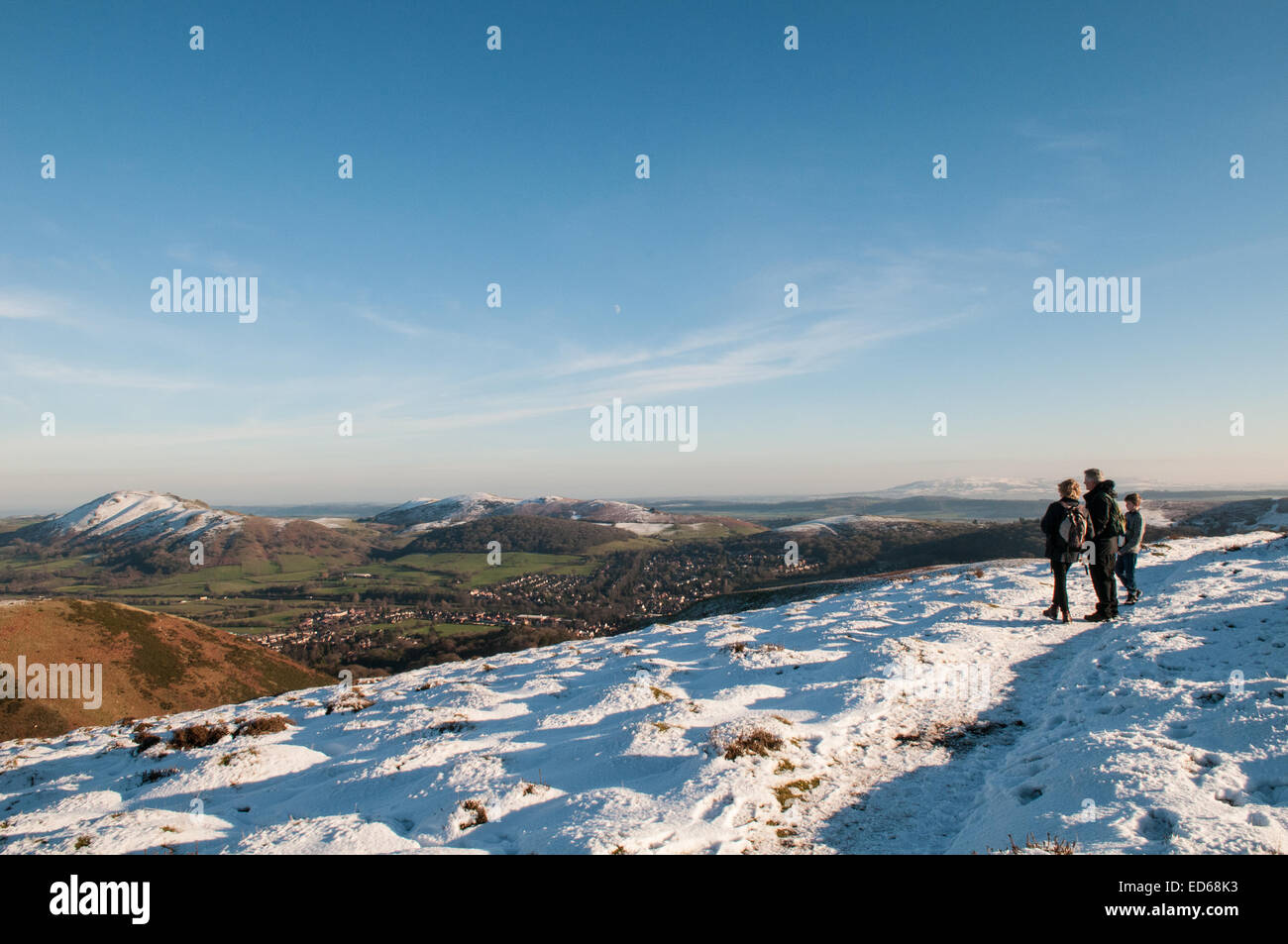 Shropshire, UK. 29th December, 2014. UK Weather: Three walkers stop to take in the stunning winter scene from the top of the Long Mynd in Shropshire, across the nestling town of Church Stretton, as the UK enjoys clear blue skies and sunshine along with freezing temperatures as 2014 comes to an end and people enjoy their Christmas and New Year break. Credit:  Jane Williams/Alamy Live News Stock Photo