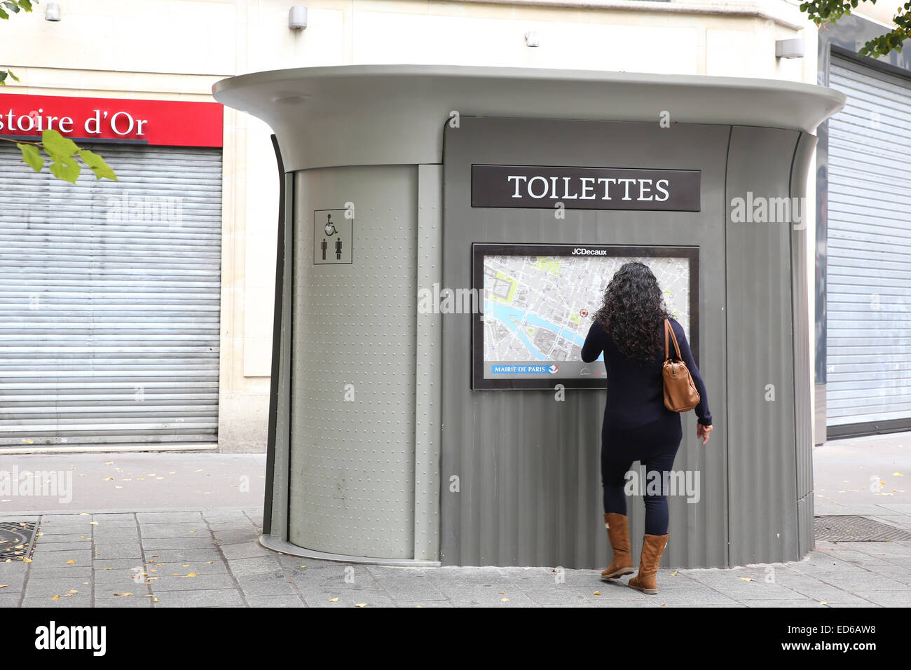 woman waiting public restroom toilet Paris street Stock Photo