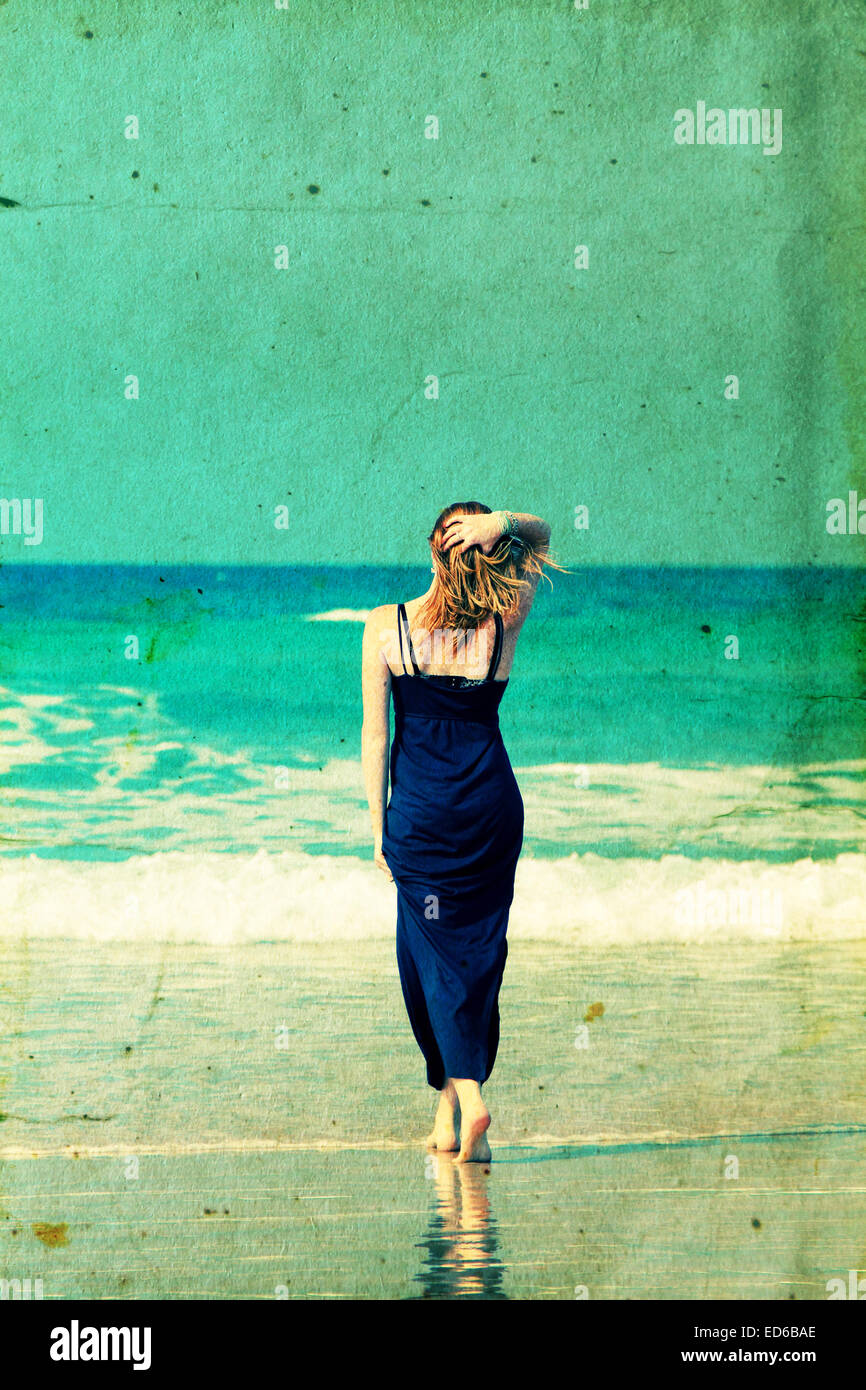 Beautiful young woman at the beach walking at the beach. Retro vintage instagram filter. Stock Photo