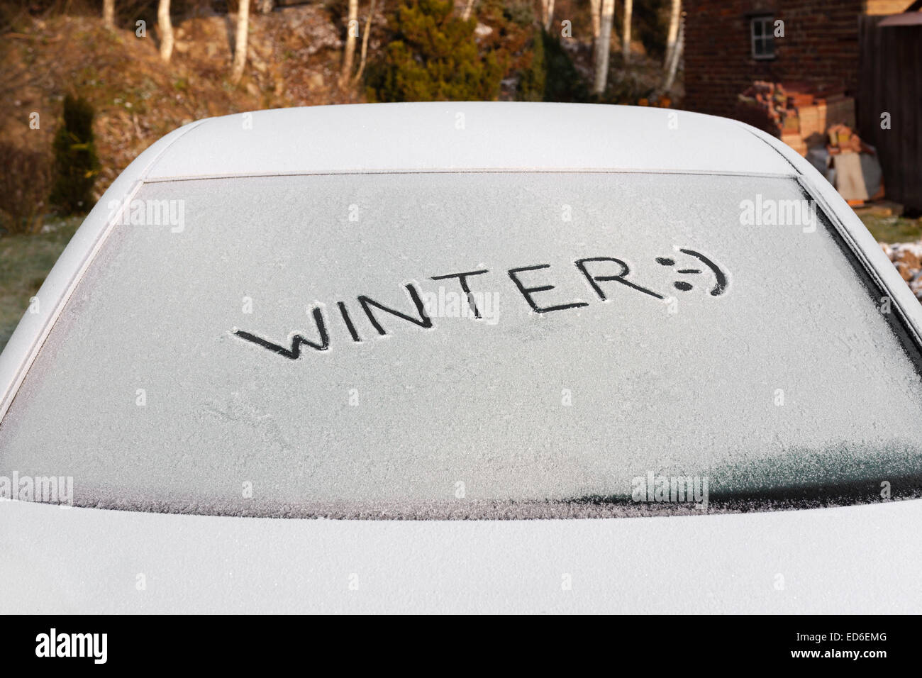 Handwritten inscription Winter on the frozen rear car glass window Stock Photo