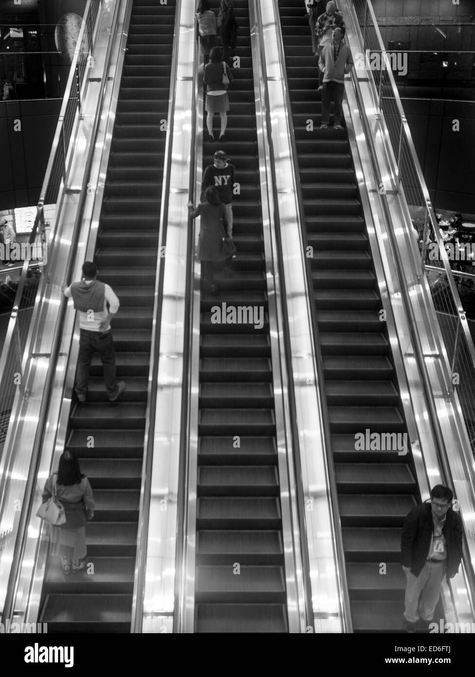 People in an escalator at night Stock Photo