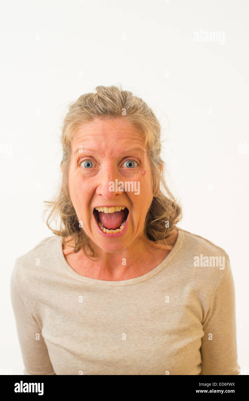 An Angry enraged furious frustrated forty year old caucasian woman against a white background. UK Stock Photo