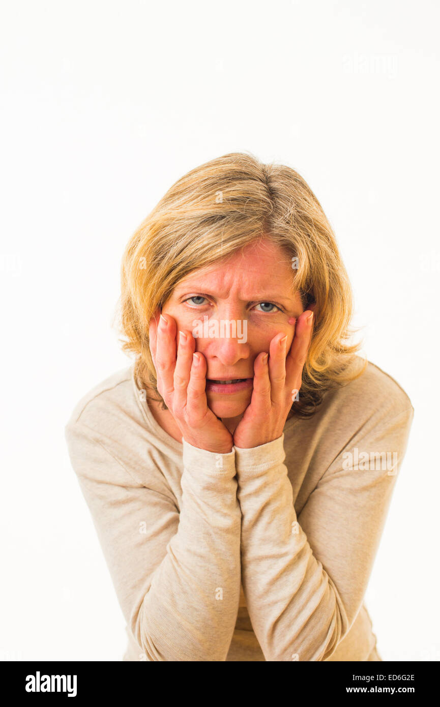 A forty year old caucasian woman looking feeling ill hungover sick unwell against a white