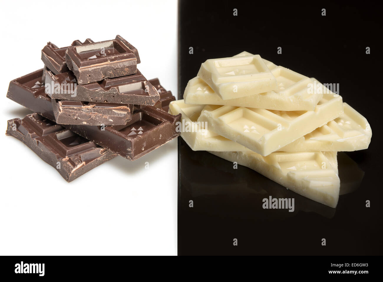 pieces of dark chocolate on a white background and white chocolate on a black background Stock Photo