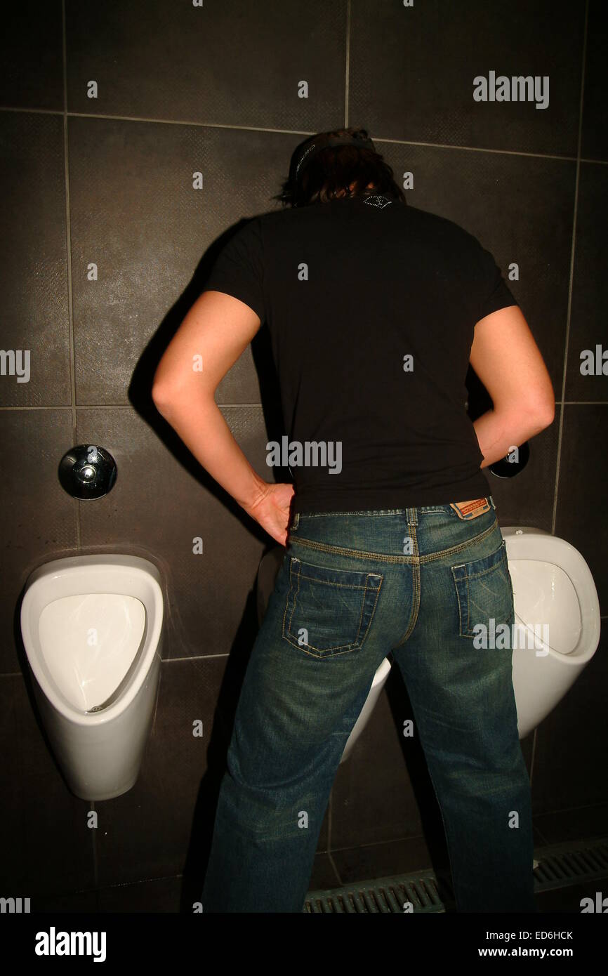 Men standing at mens urinal, toilet, public Stock Photo