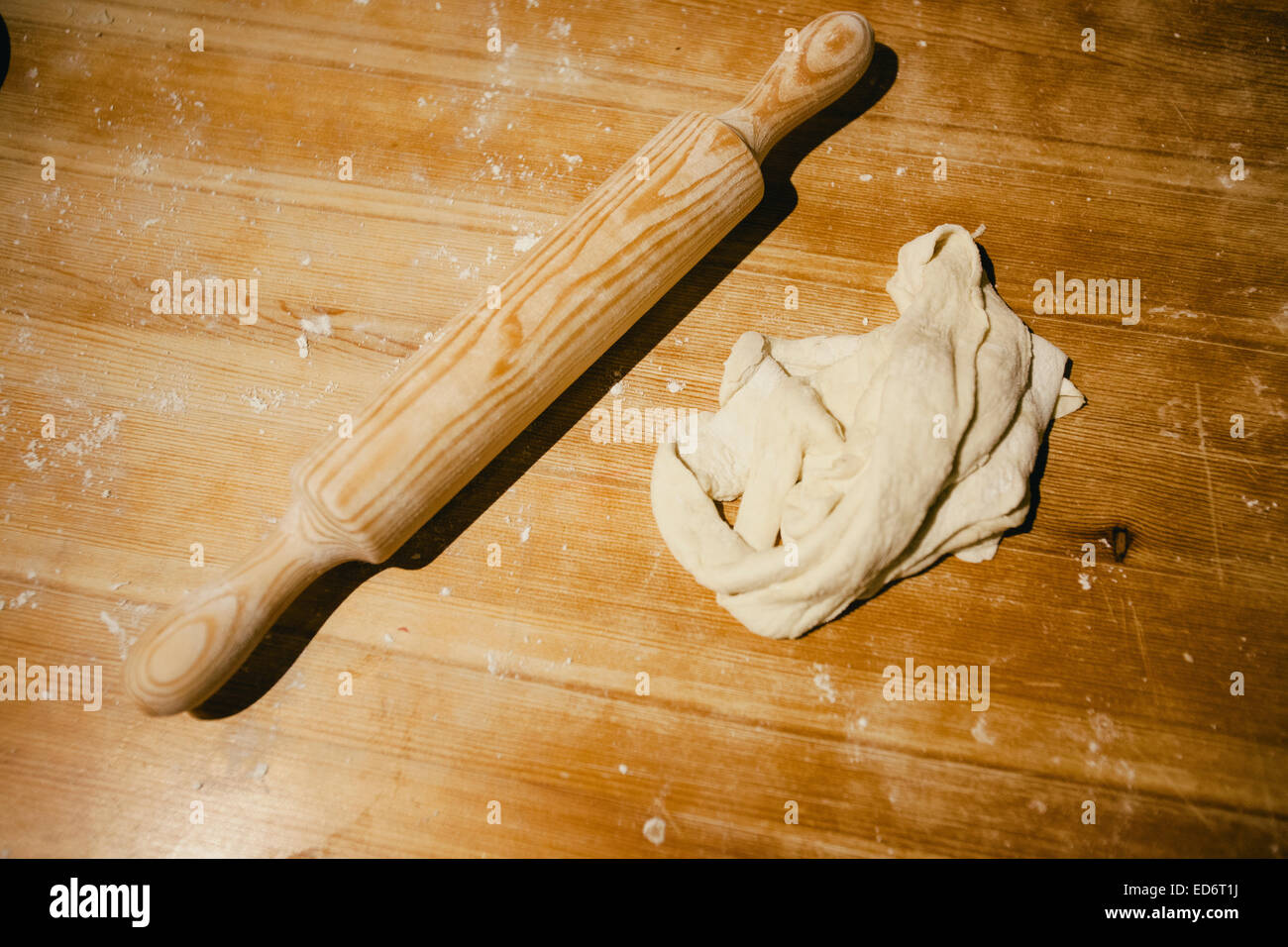 Bread dough and a roller on a wooden table Stock Photo