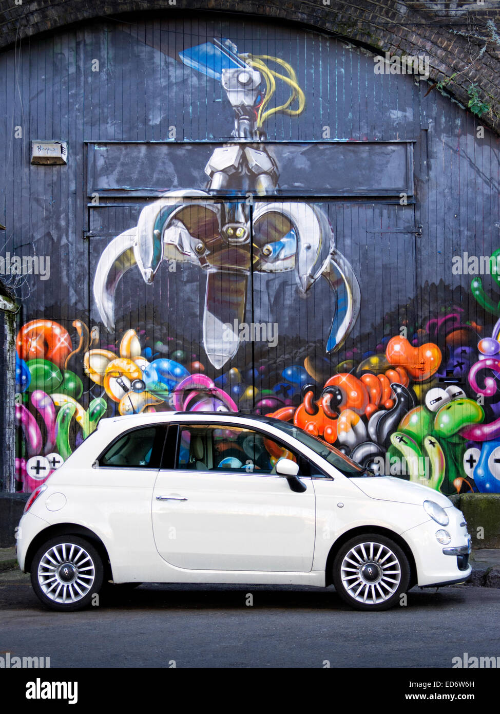 Fiat 500 parked in Street in Camden Town with street art in background Stock Photo