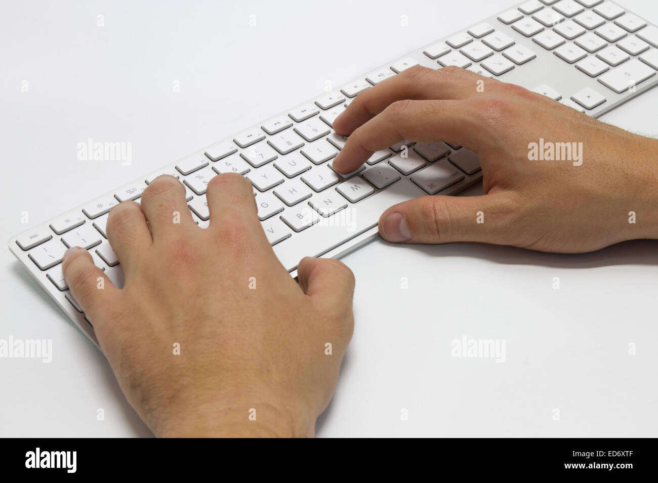 hands typing on the white wireless keyboard Stock Photo