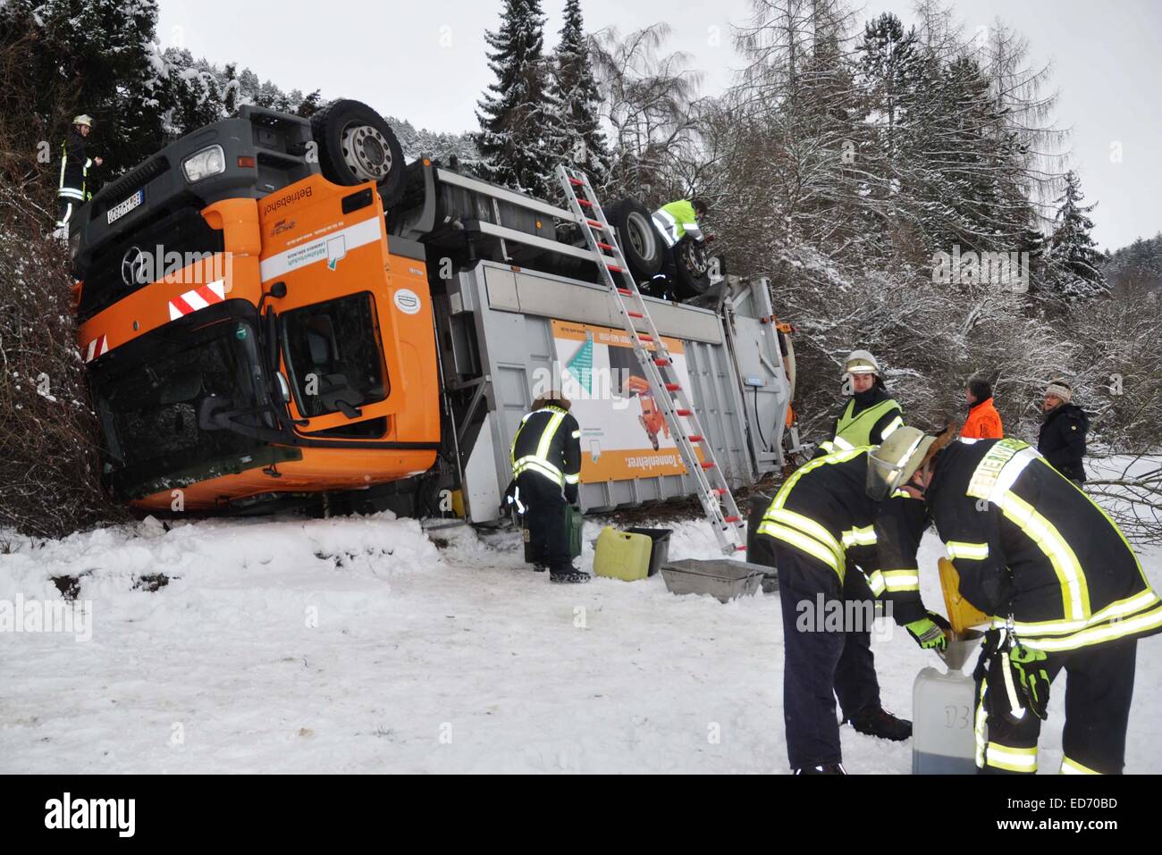 A disposal vehicle flipped onto its roof lies in Aidlingen, Germany, 30 December 2014. The 25 ton vehicle slid down a slope while reversing. PHOTO: ANDREAS ROSAR/dpa Stock Photo