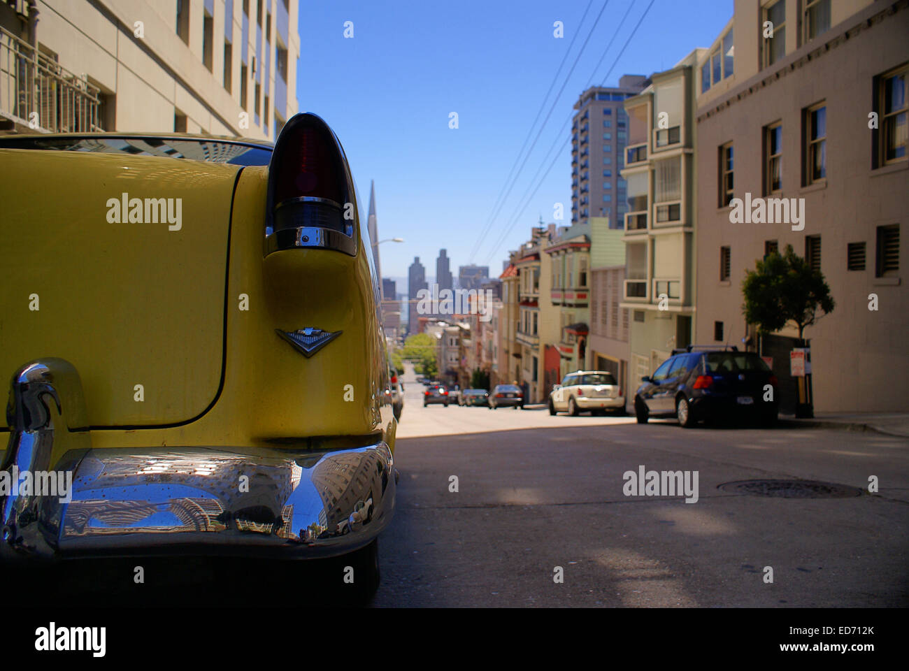 Yellow Crazy Taxi-like rear end of a car on a hill in San Francisco Stock Photo