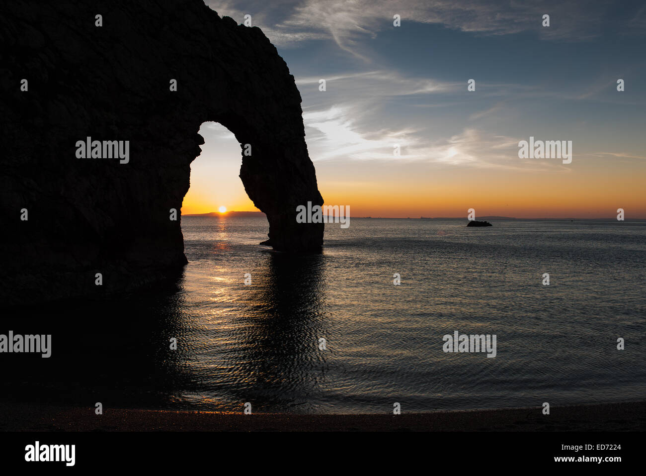 The Sun Sets Through the Limestone Arch of Durdle Door Stock Photo