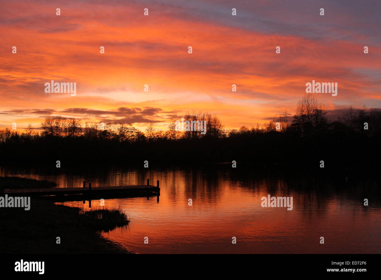Winter solstice sunset reflected in the water at Lakeside Country Park, Eastleigh, Hampshire, England, UK Stock Photo