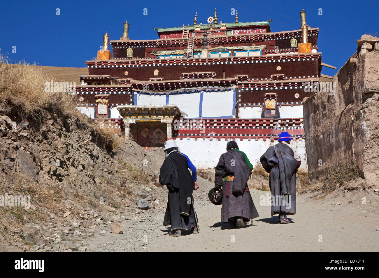 Tibetan pilgrims walking in the village Sershu / Serxu, Sichuan Province, China Stock Photo