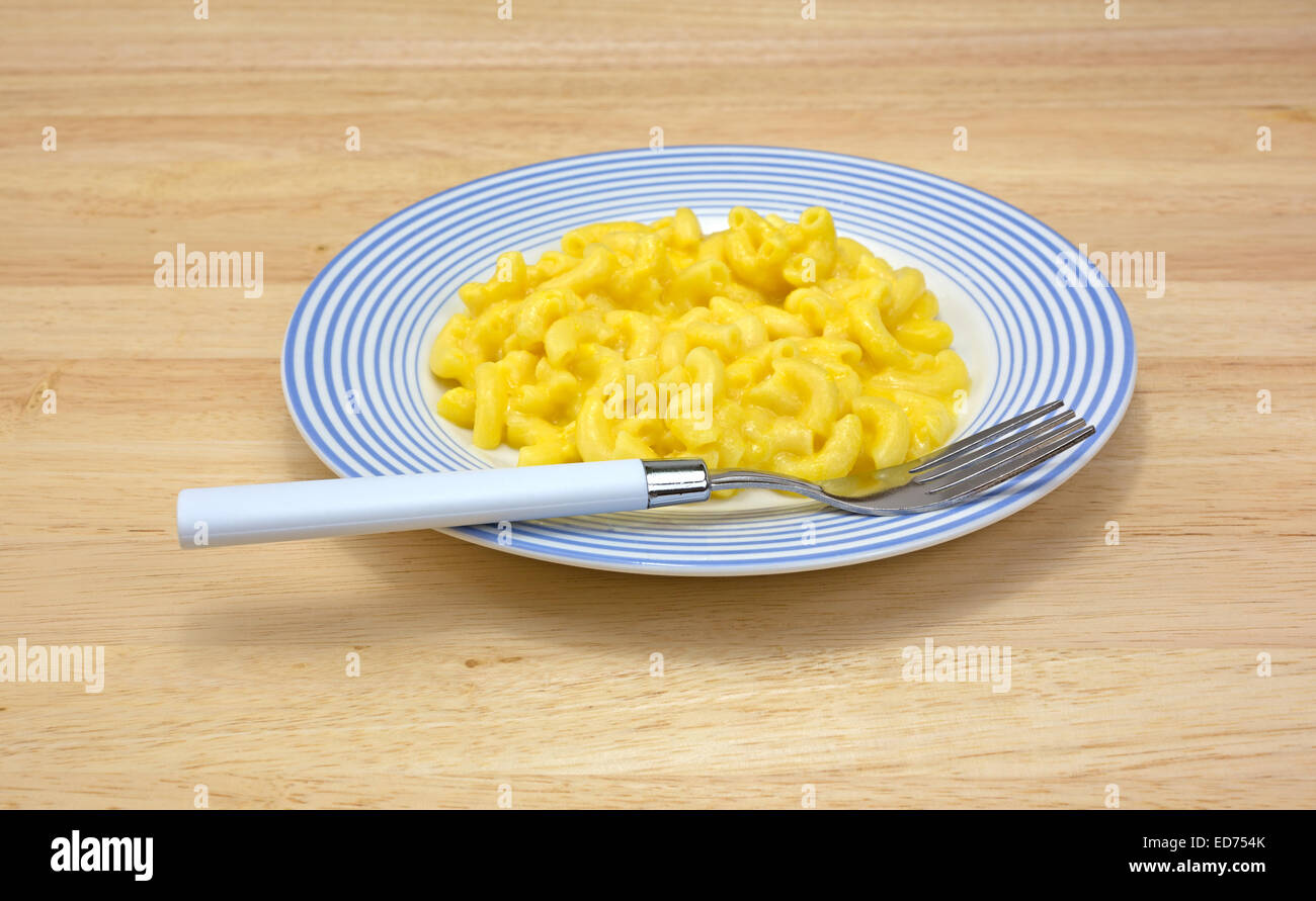 A serving of macaroni and cheese on a plate with fork. Stock Photo