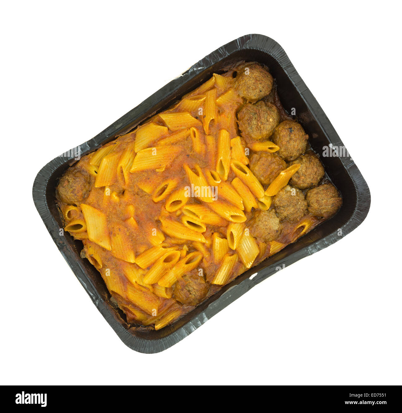 Top view of a very large serving of penne pasta in a tomato sauce with meatballs in a black tray atop a white background. Stock Photo