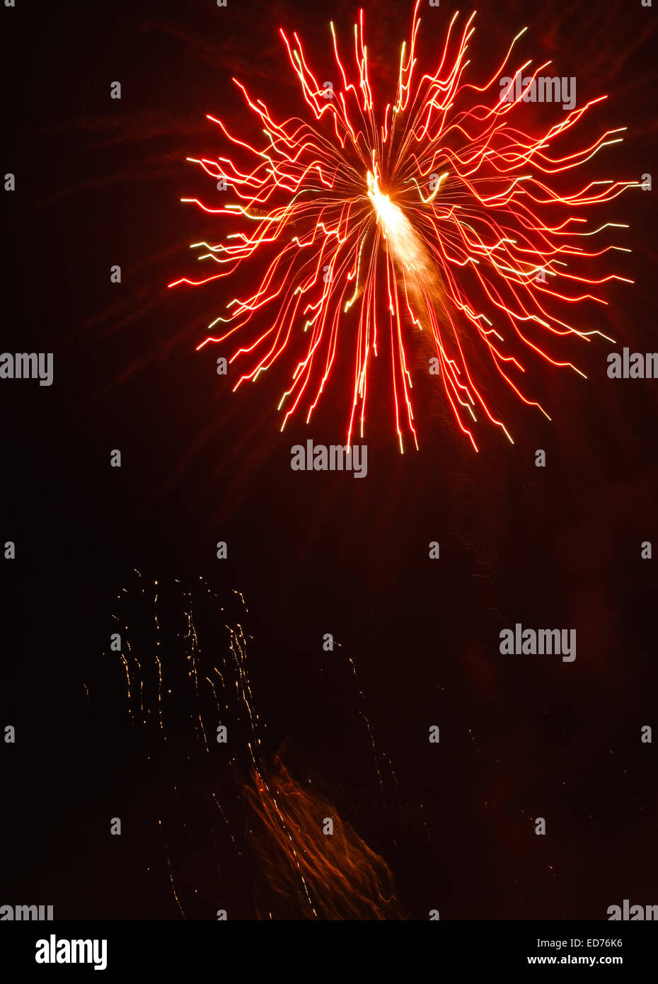 Fireworks bursting in the night sky - orange and red sparks Stock Photo