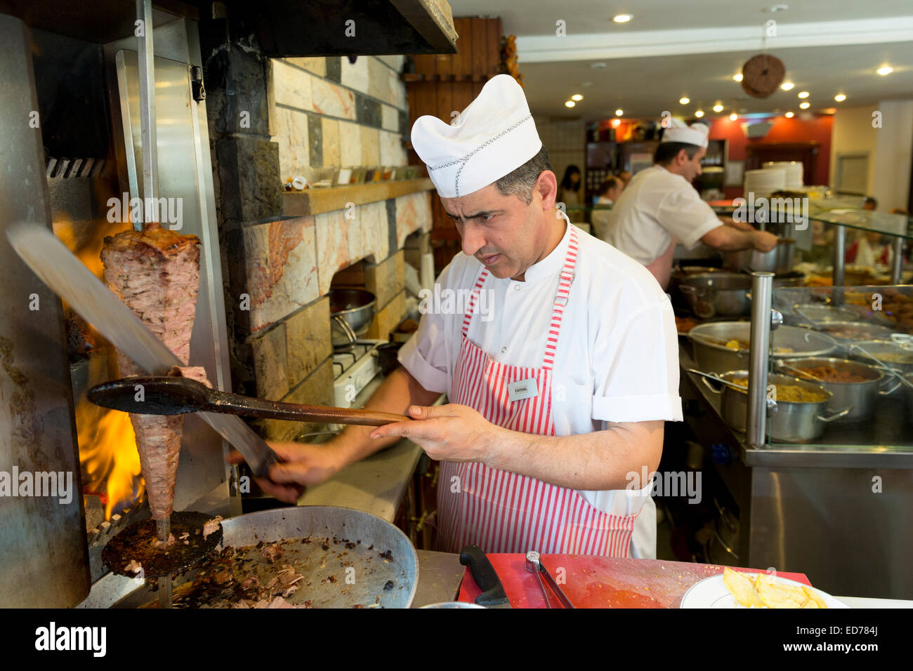 Chef at Ciya Sofrasi Turkish restaurant slicing and serving traditional lamb doner kebab in Kadikoy district on Asian side of Is Stock Photo