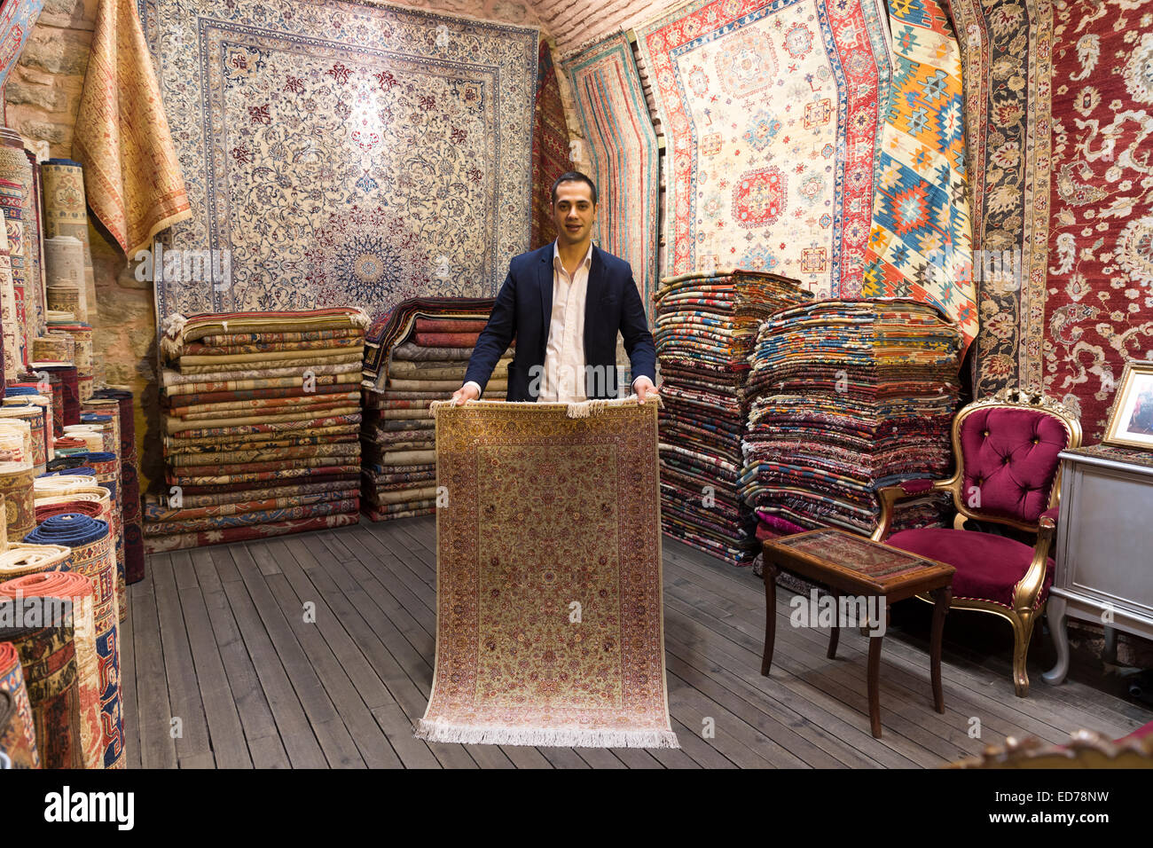 Salesman with traditional Turkish carpet rug in The Grand Bazaar