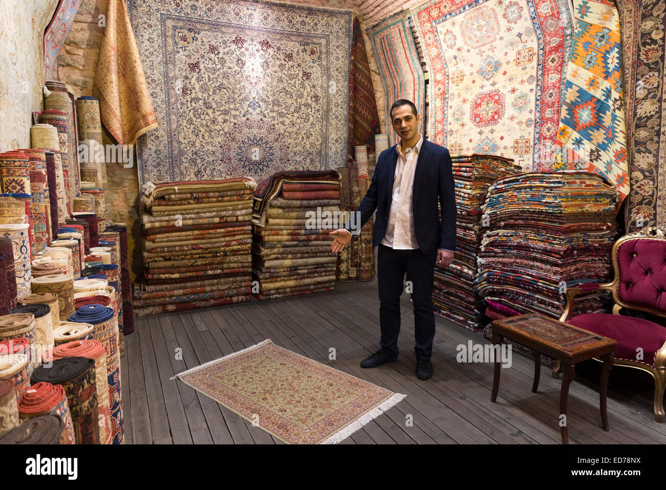 Salesman with traditional Turkish carpet rug in The Grand Bazaar