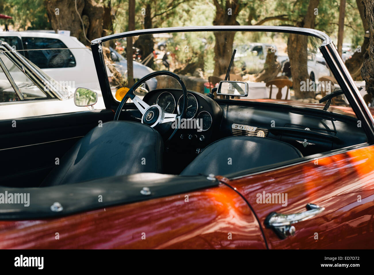 Classic convertible open top Alfa Romeo sports car - parked under trees - Mani Peninsula, Peloponnese, Greece Stock Photo