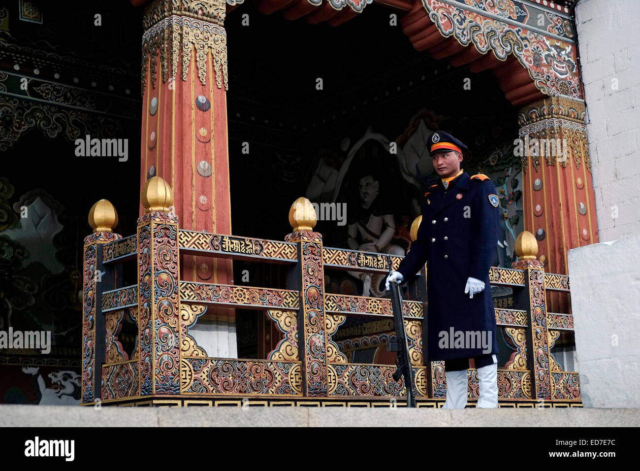 An armed sentry stands firm at the entrance to the government offices in Tashichho Dzong fortress seat of Bhutan's government since 1952 and presently houses the throne room and offices of the king on the edge of the city of Thimphu the capital of Bhutan Stock Photo