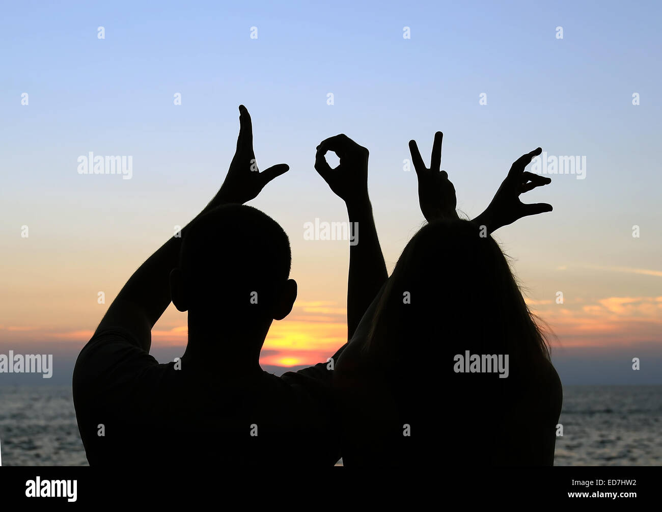 A Silhouette Of A Romantic Couple Holding Their Hands Spelling The Word Love On The Background Of A Sea Sunset A Silhouette Of A Romantic Couple Holding Their Hands Spelling The Word Love On The Background Of A Sea Sunset