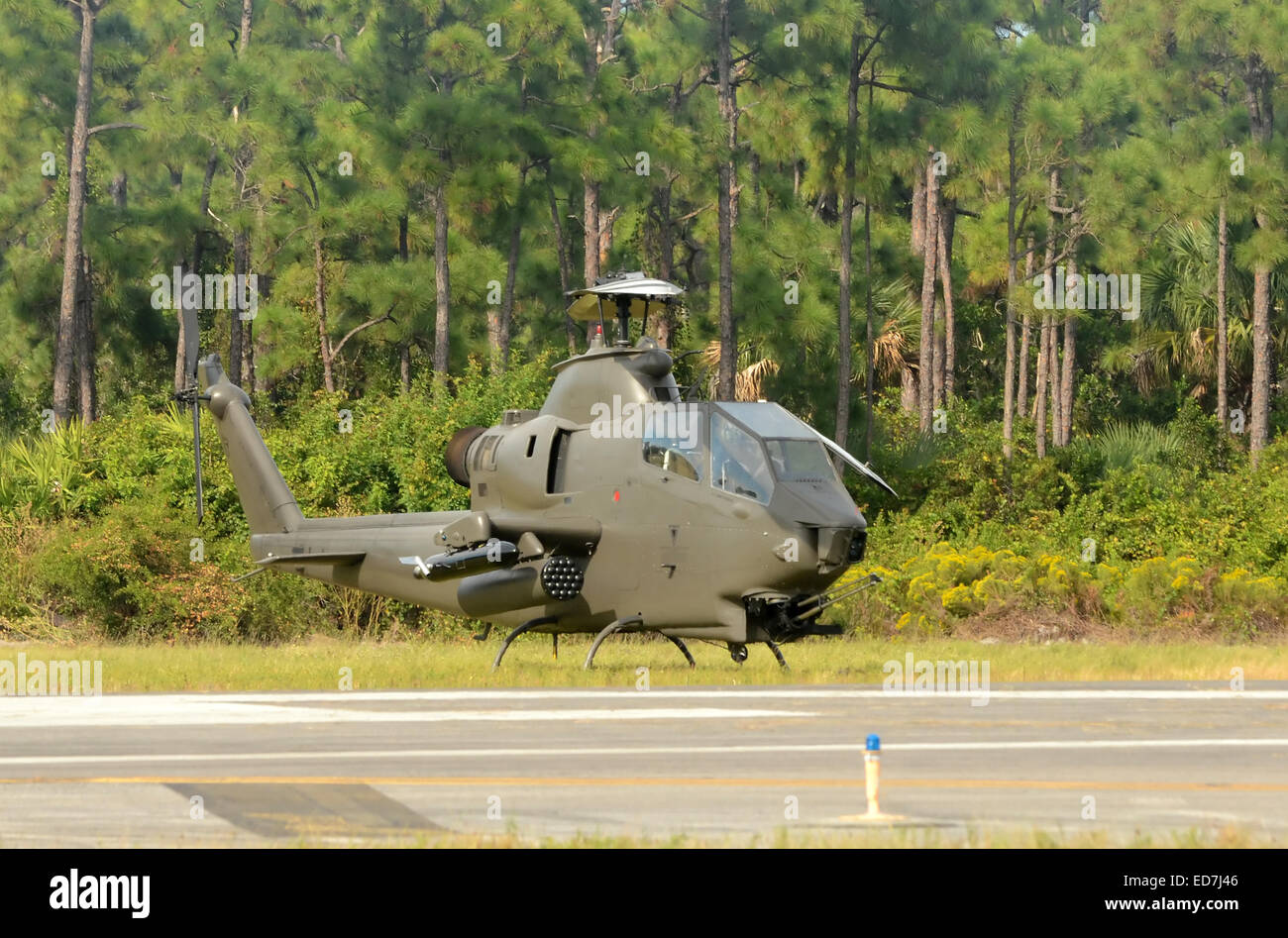 Military helicopter parked in front of trees Stock Photo