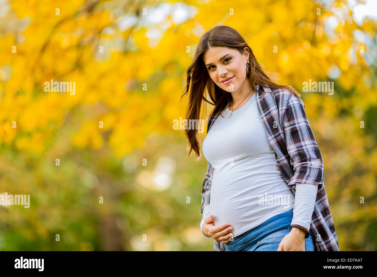 Young pregnant woman in the autumn park Stock Photo - Alamy