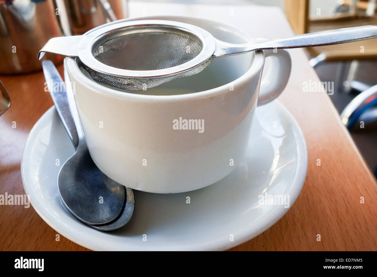 Cup of tea being poured using a tea strainer Stock Photo Alamy