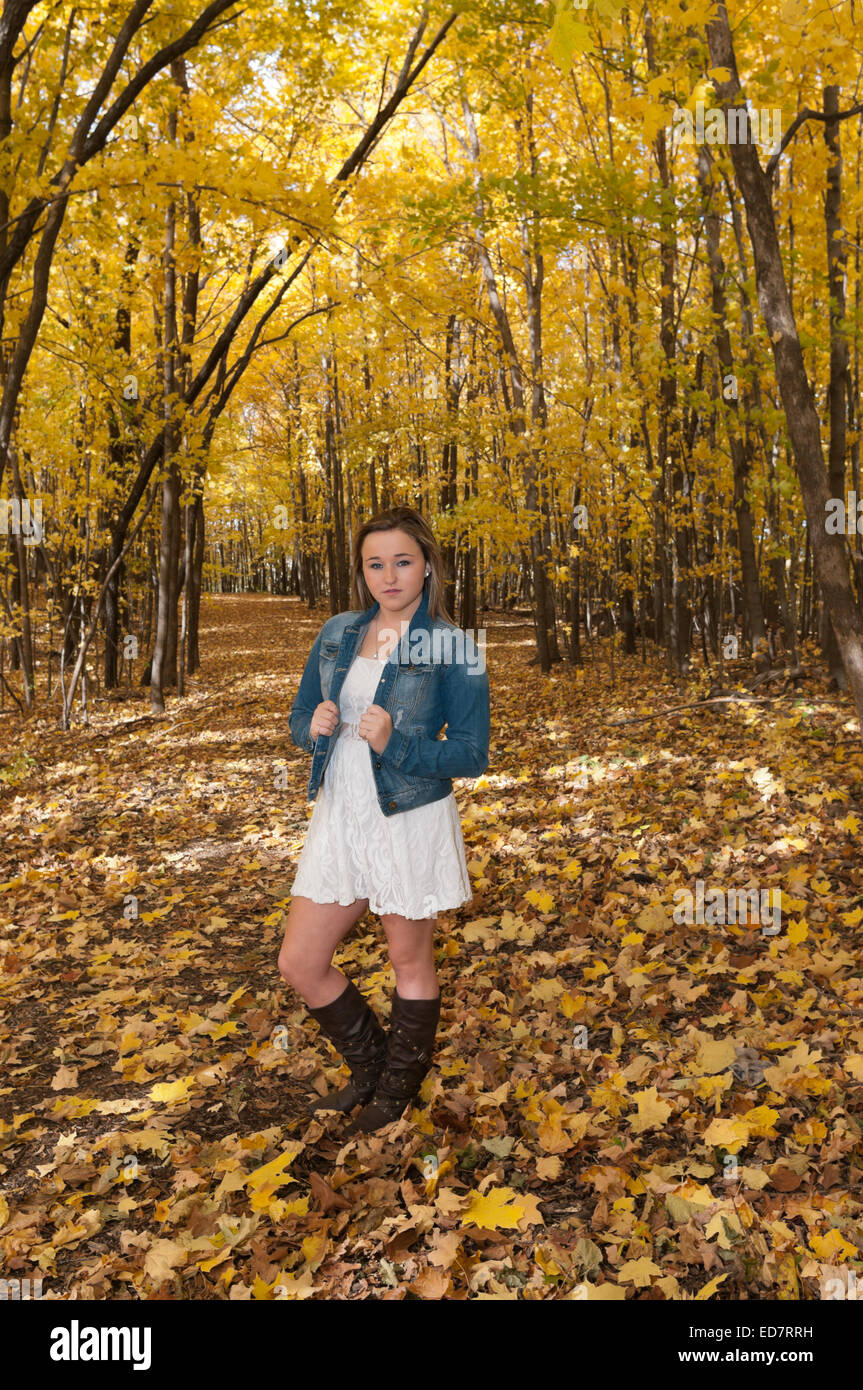full length portrait of young female teen standing on forest trail in autumn Stock Photo