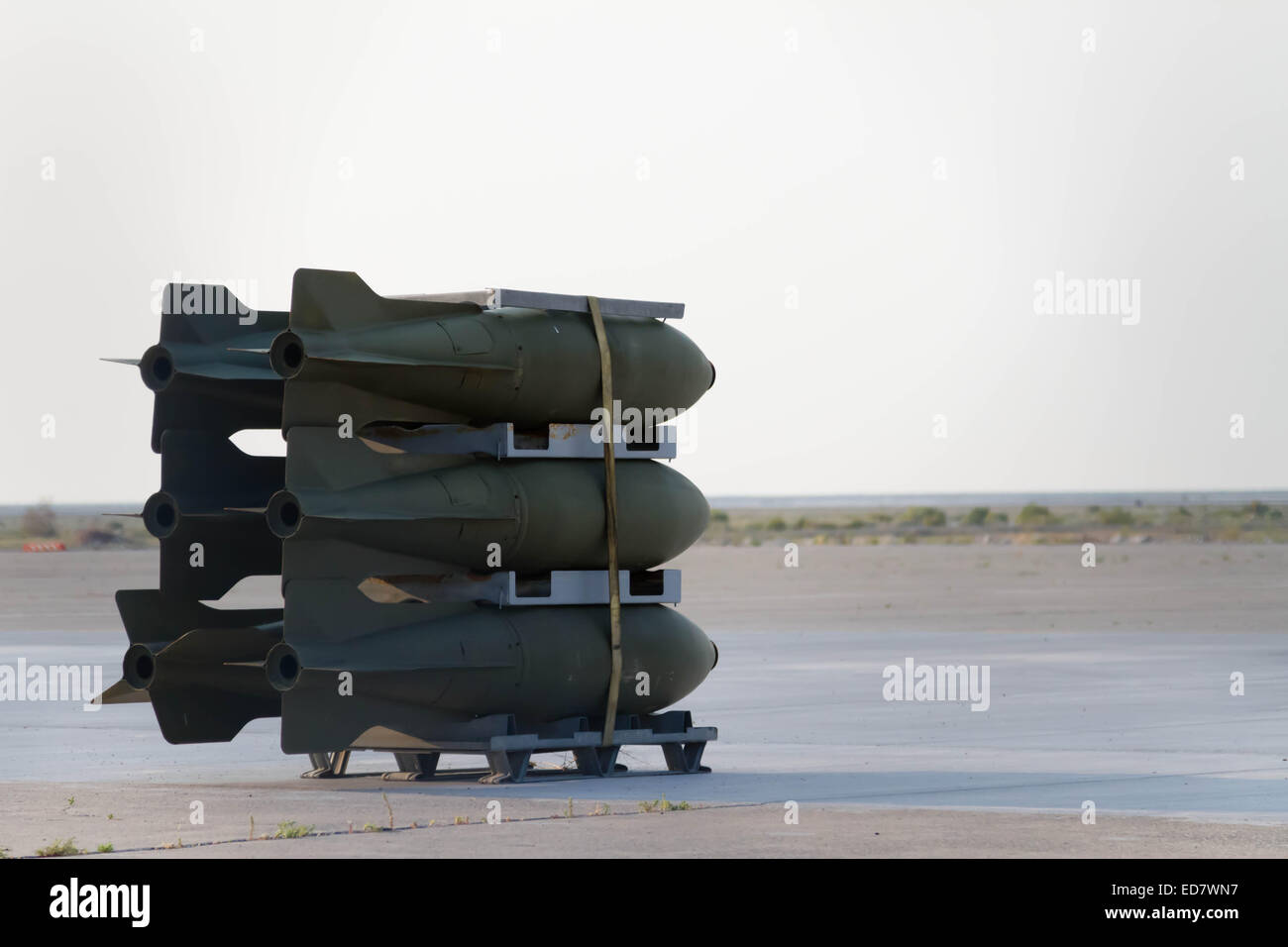Outdated bombs sitting on an airplane runway in the desert. Stock Photo