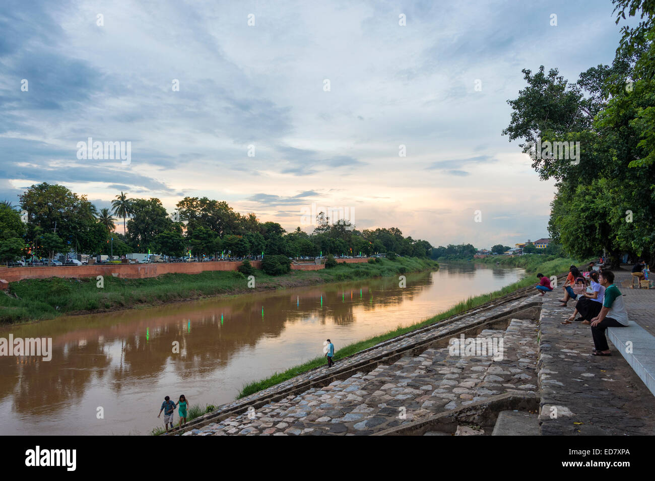 Local people enjoy the sunset on the banks of the Nan River in Phitsanulok, Thailand Stock Photo