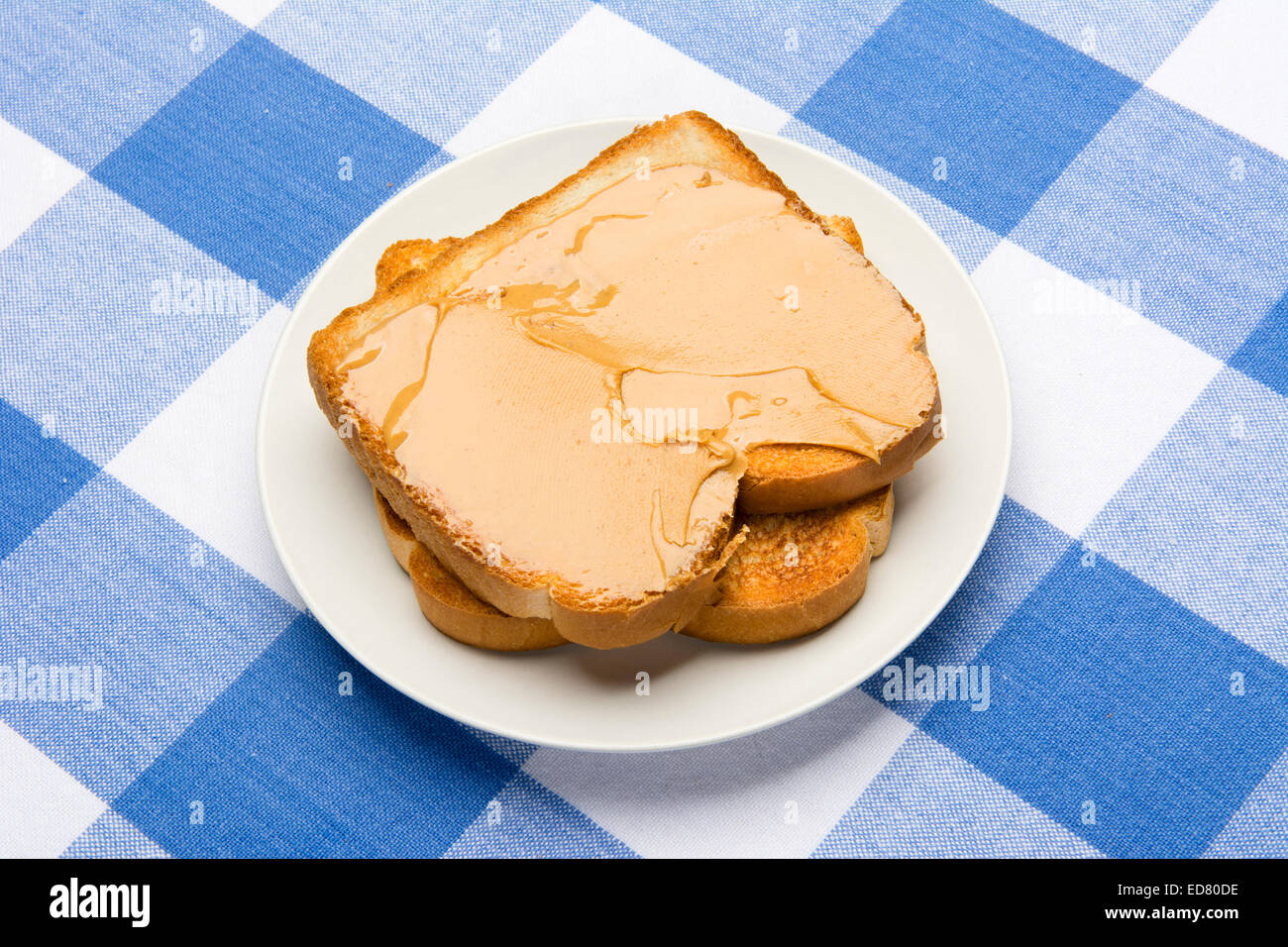 Fresh, hot breakfast toast spread with peanut butter to be consumed