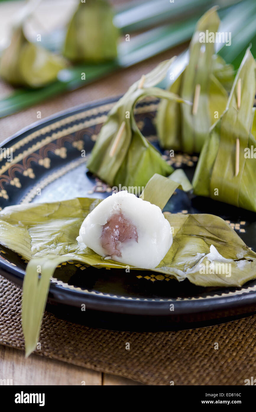 Thai traditional dessert made of coconut milk,rice flour with grated coconut and  palm sugar filling Stock Photo